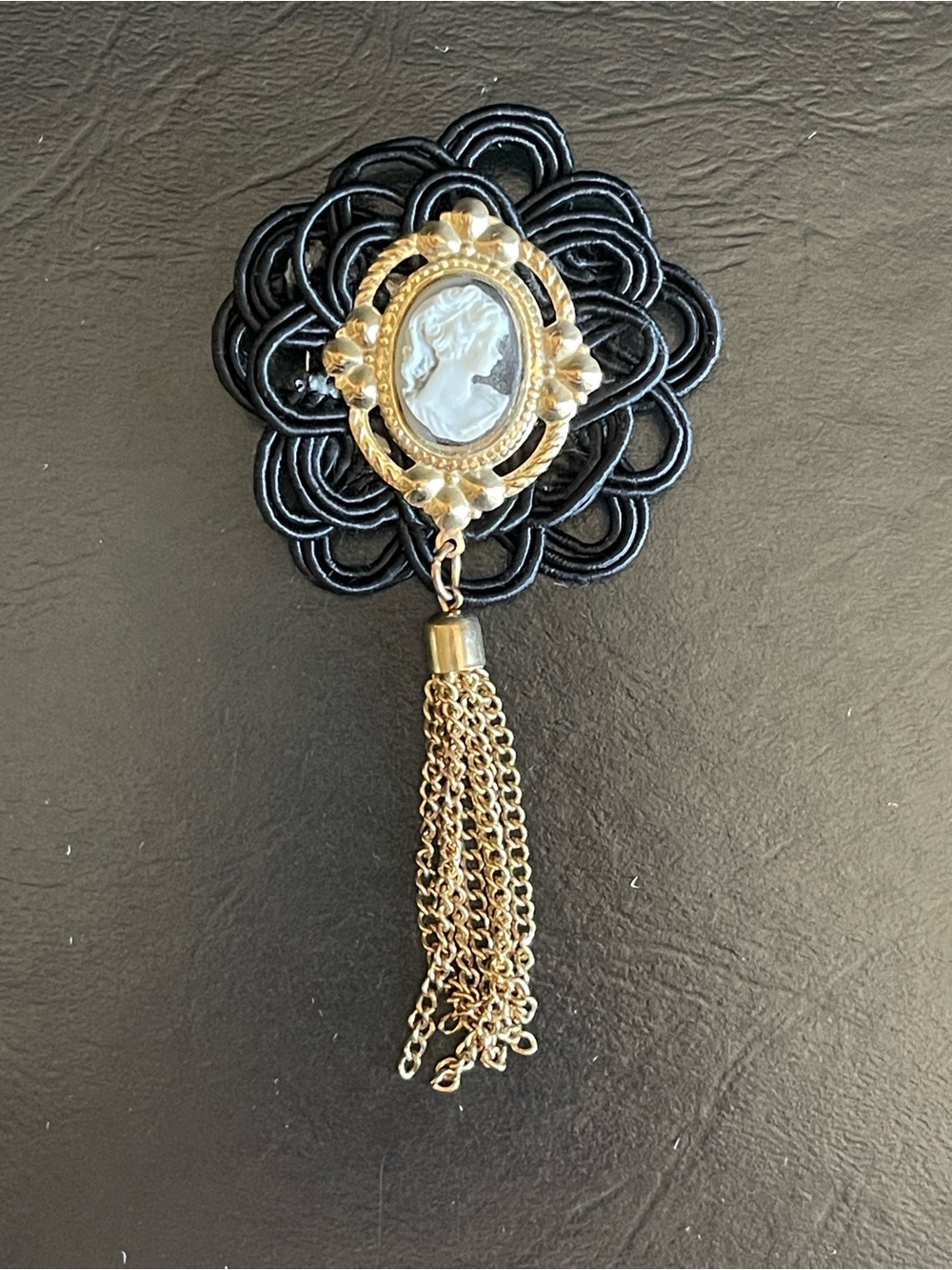 Vintage-Inspired Black and Gold Cameo Tassel Brooch.